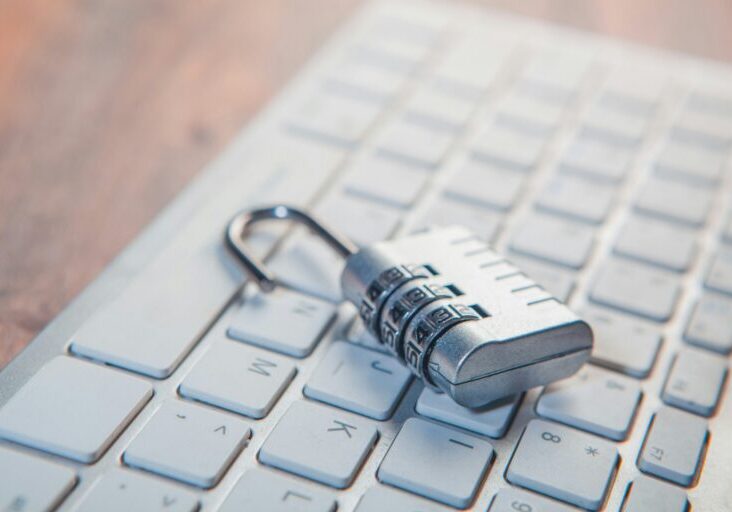 A combination lock rests on a computer keyboard.